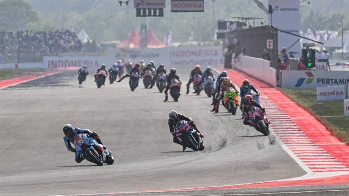 Barisan pebalap menikung di Sirkuit Mandalika pada MotoGP Indonesia 2026 dengan spanduk Pertamina dan Indonesia di sisi lintasan